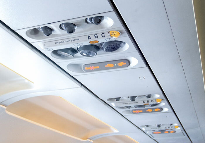 Closeup image of air ventilation holes and individual lights over the passenger seat in aircraft